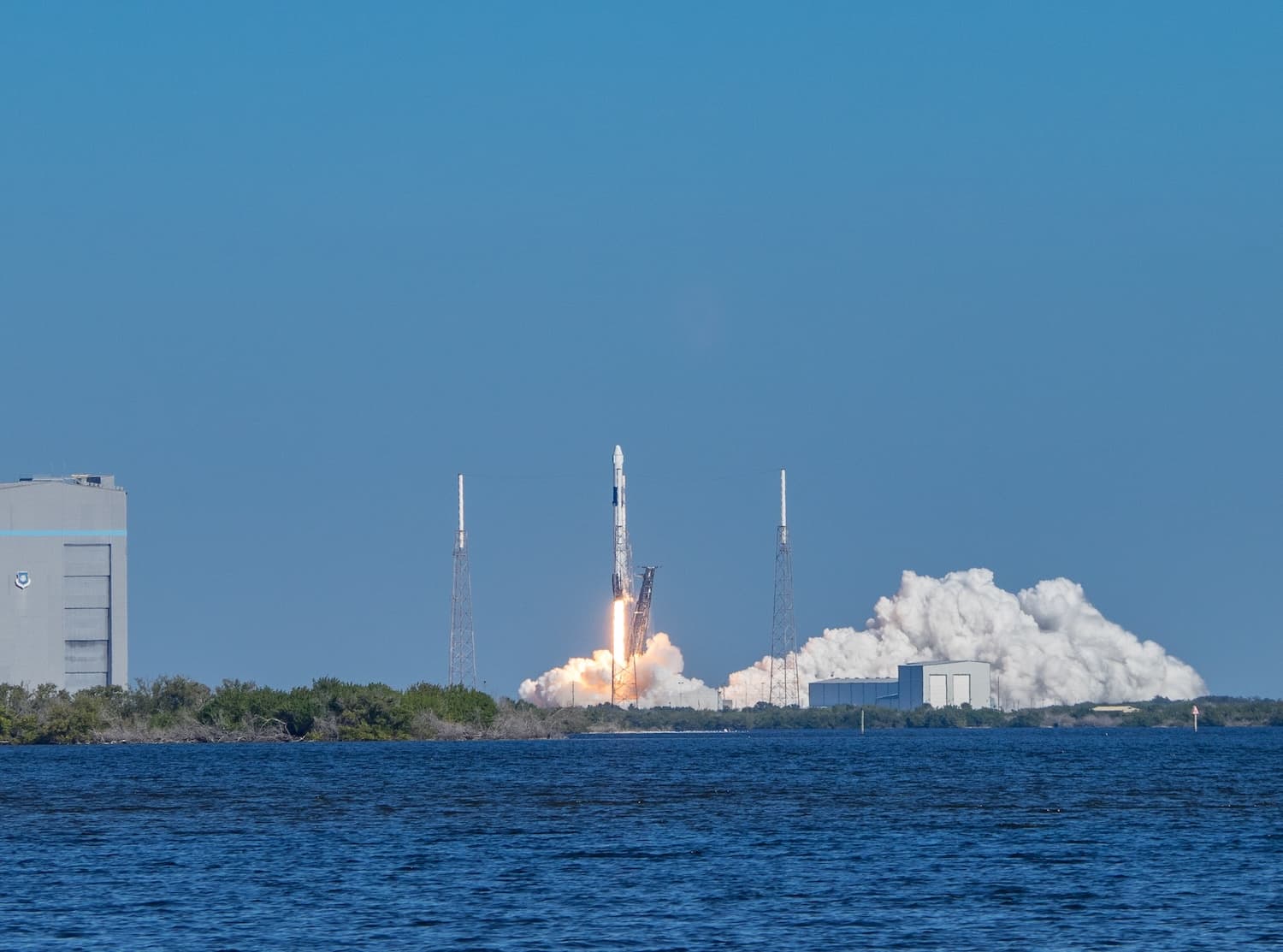SpaceX Falcon 9 rocket launching from Cape Canaveral viewed across the water