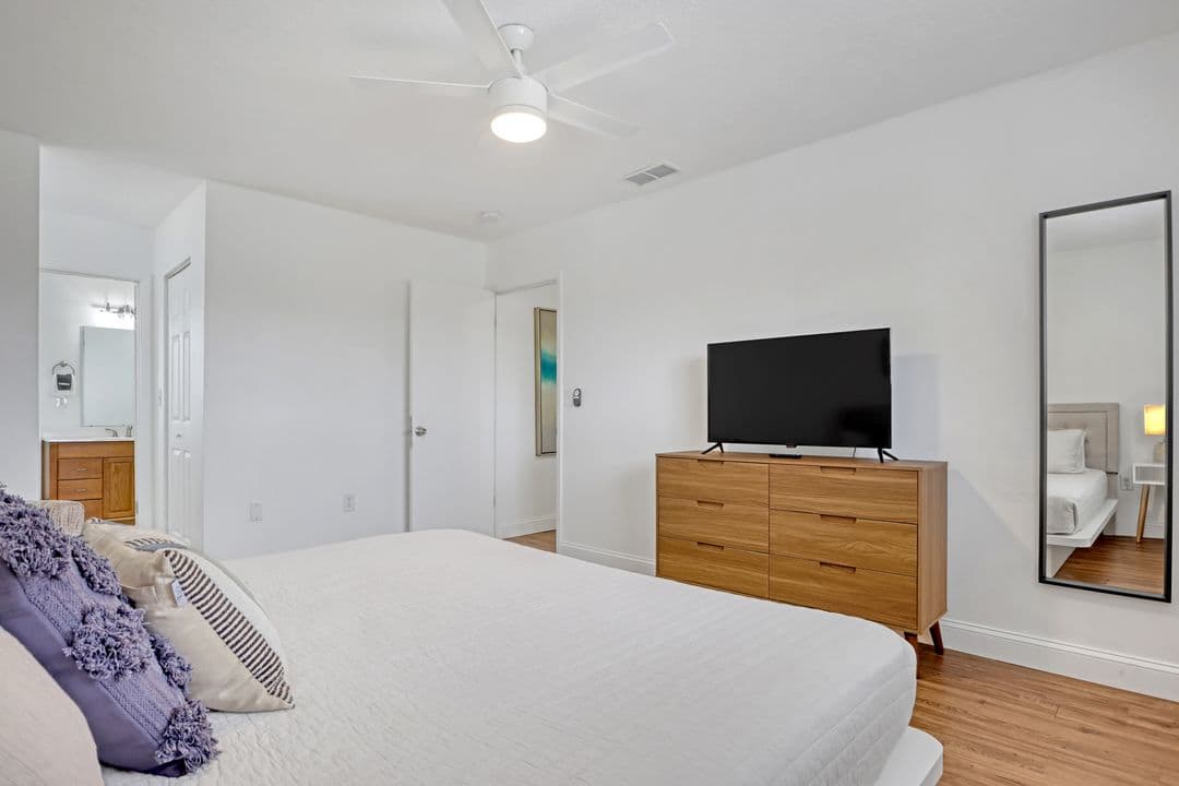 Master bedroom with king bed, TV, and en-suite bathroom